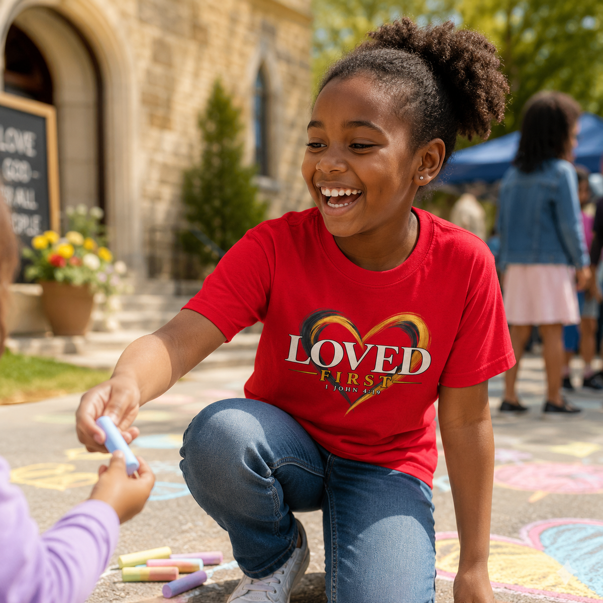 Youth wearing the He First Loved Us shirt during a church chalk activity