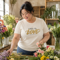 Woman wearing This Is Love 1 Corinthians 13:4-7 Christian T-shirt at a floral workshop